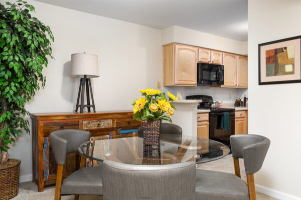 A dining room with a kitchen view at Chesterfield Village Apartments