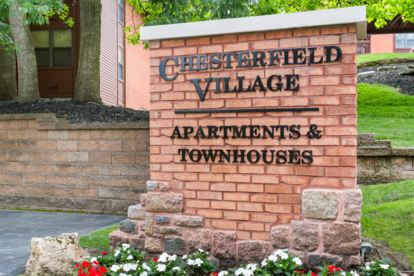 A close up of a brick sign of The Chesterfield Village Apartments
