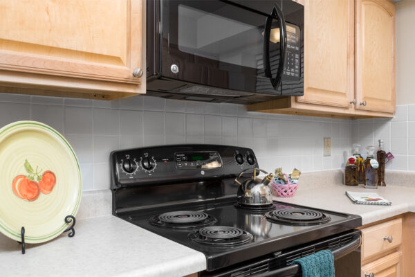 A stovetop and microwave at Chesterfield Village Apartments