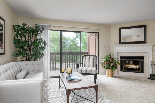 A living room and fireplace at Chesterfield Village Apartments