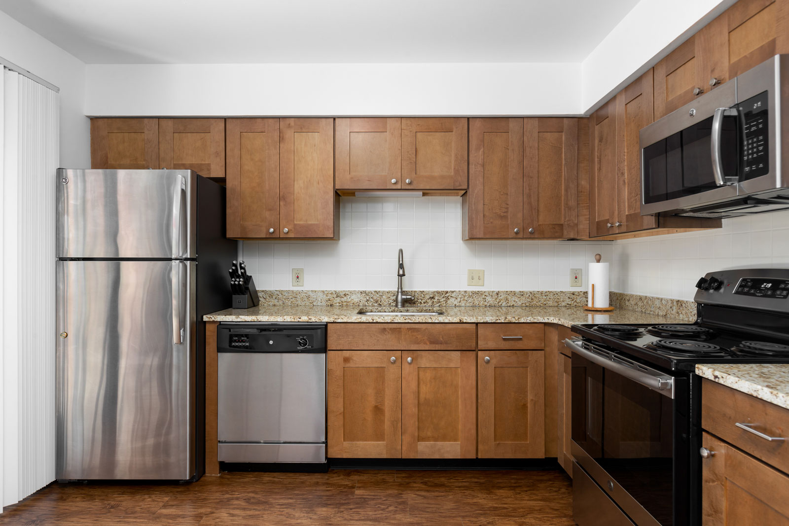 A kitchen with cabinets and stainless steel appliances at Chesterfield Village Apartments