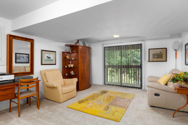 A basement living room with a recliner and sofa at Chesterfield Village Apartments