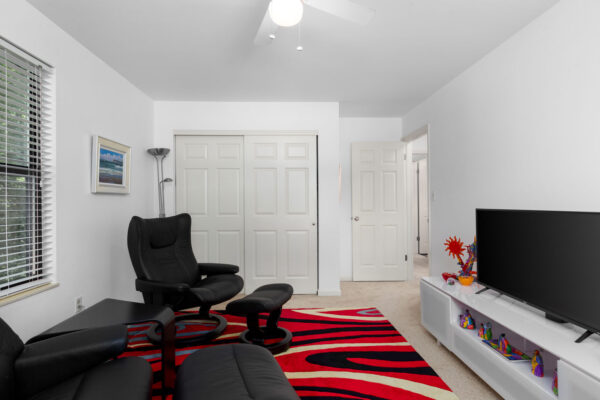 a room with chairs and a television at Chesterfield Village Apartments